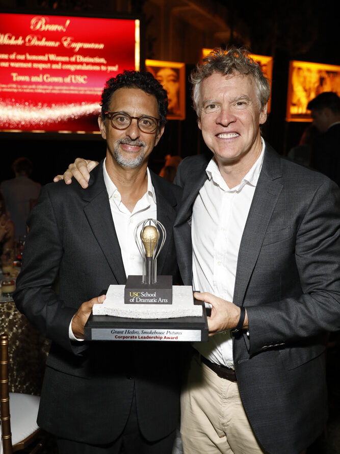 Honoree Grant Heslov and Tate Donovan hold Heslov's the award statue for Corporate Leadership Award