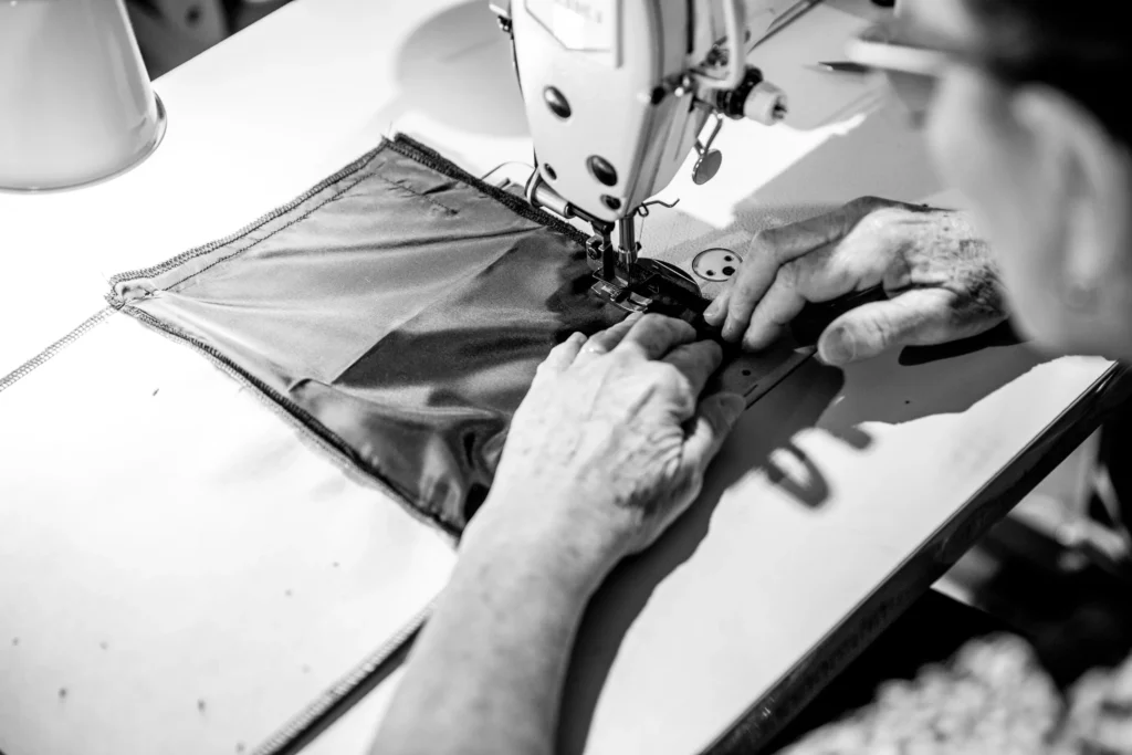 A Scenery Bags purse is being sewn together on a sewing machine