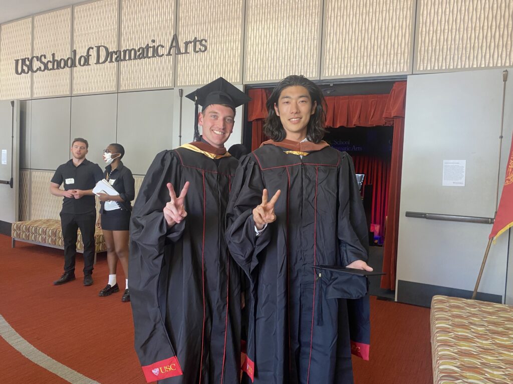 Two graduate students posing with Fight On signs