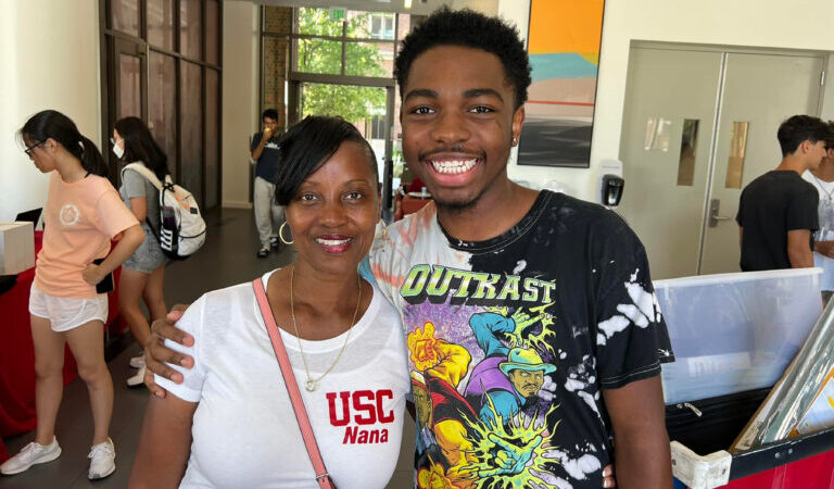 Image of new student and his grandmother on move in day