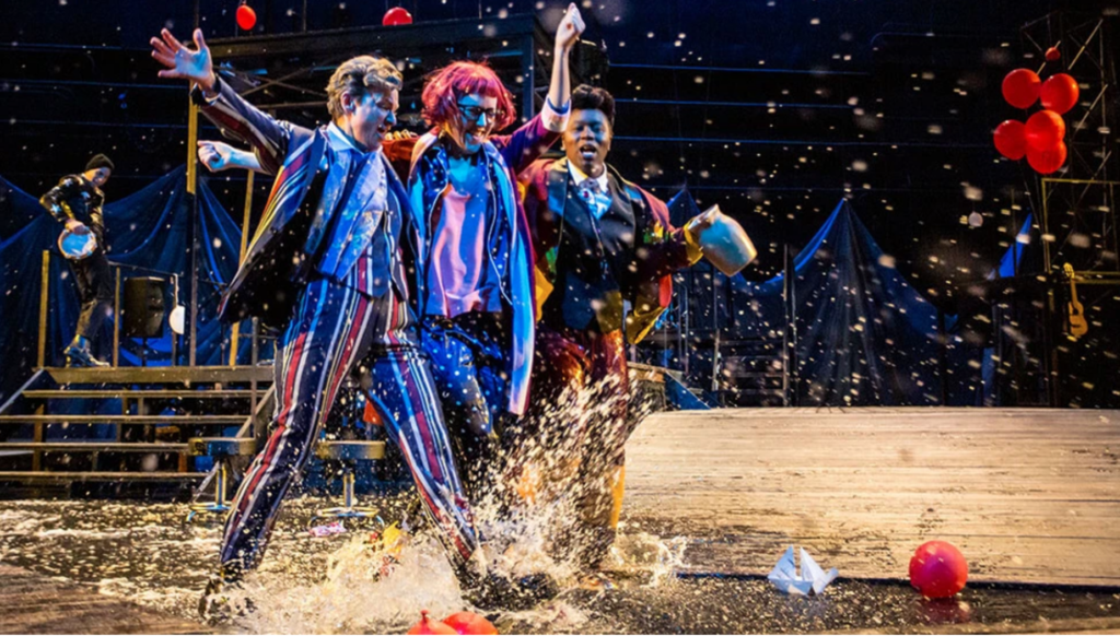 Three actors on a stage in colorful clothing