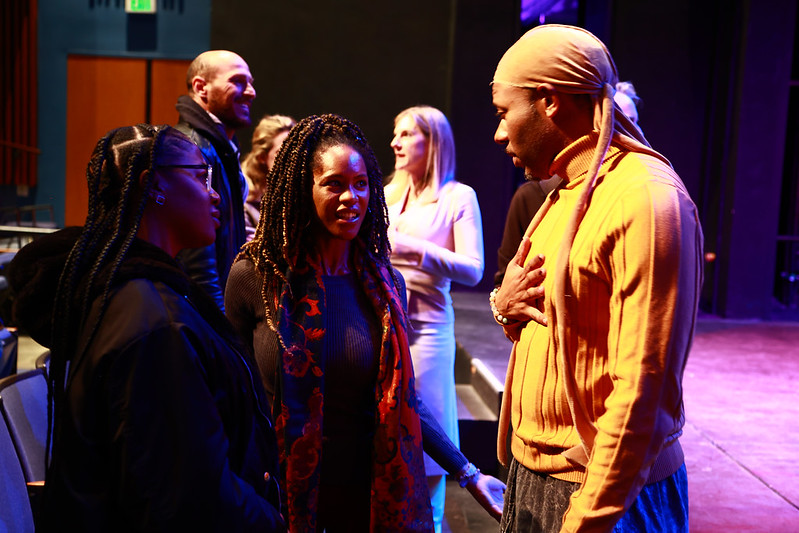 Larry Powell gestures as he speaks with two audience members following the masterclass.