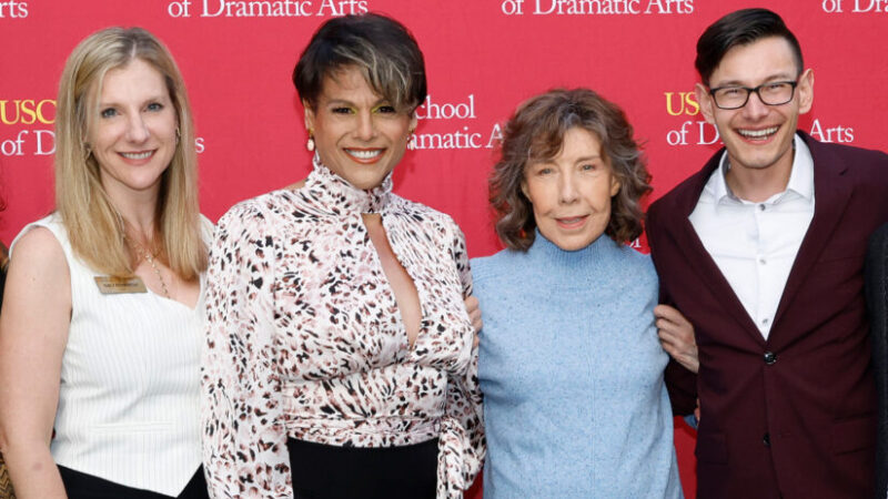 Alexandra Billings poses with Emily Roxworthy and two others in front of an SDA cardinal and gold banner