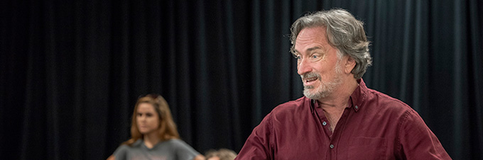 A professor teaches from a stage.