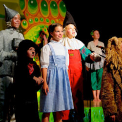 A cast of young actors performs a scene from the Wizard of Oz.