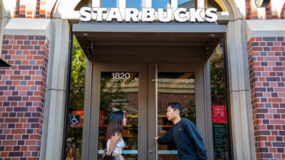 Two students entering a Starbucks in University Village.