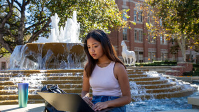 A student working at their laptop in University Village.
