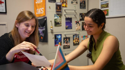 A student speaking with an academic advisor in their office.