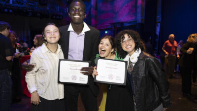 Two award-winning students and presenters display their award certificates.