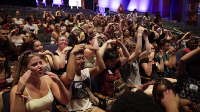 A crowd of students celebrating and making gestures at the 2024 New Student Welcome.