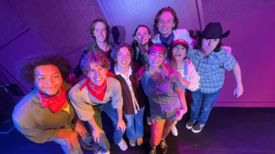 Members of the Merry Men pose against a purple background.