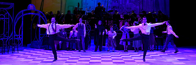 musical theatre minor_680x226 Two dancers spin and kick out their legs on a lighted stage.