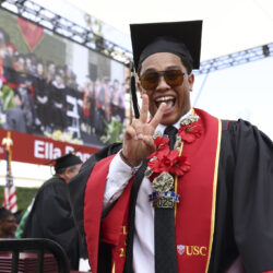 A happy graduate signals 'fight on' to the camera.