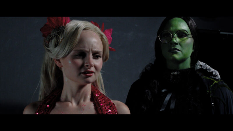 Photo of two student actors dressed as Elphaba and Glinda for the halftime spectacular.
