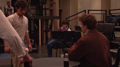 Image of Stephanie Shroyer seated with actors in the foreground.